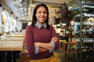 empreendedora feliz com seu negócio ao fundo